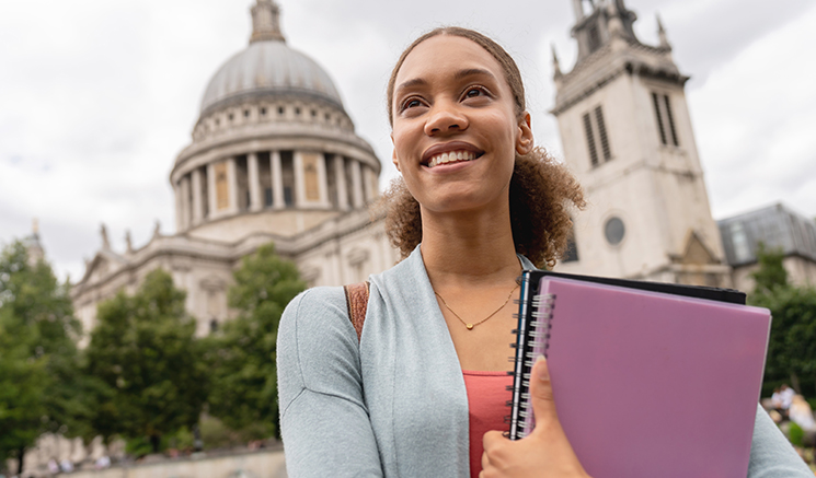 Retrato de una estudiante de inglés reflexiva en Londres sosteniendo sus cuadernos alrededor de St Paul: conceptos educativos