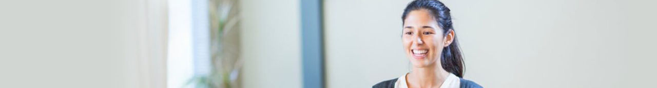 Woman standing in front of a group of people who are clapping