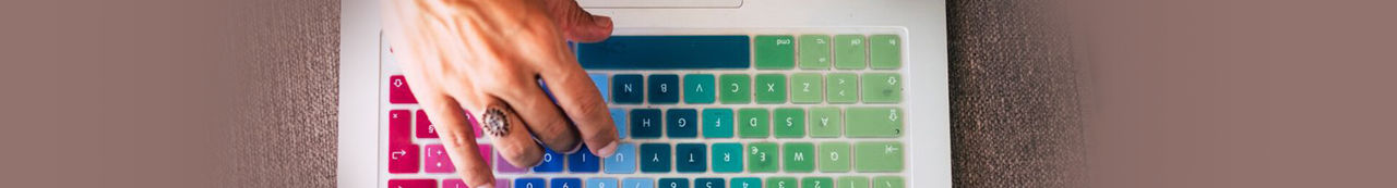 Hand typing on colorful keyboard