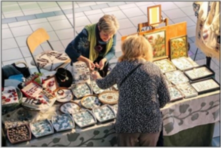 photo of someone at an outdoor craft-stand talkng to the proprietor