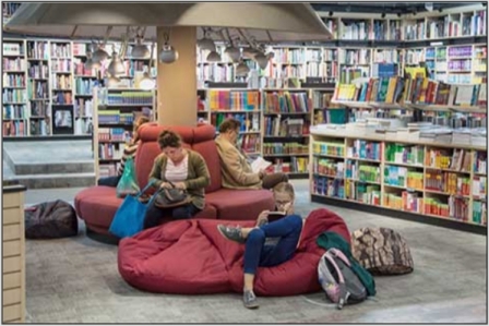 photo several people lounging and reading in a library.