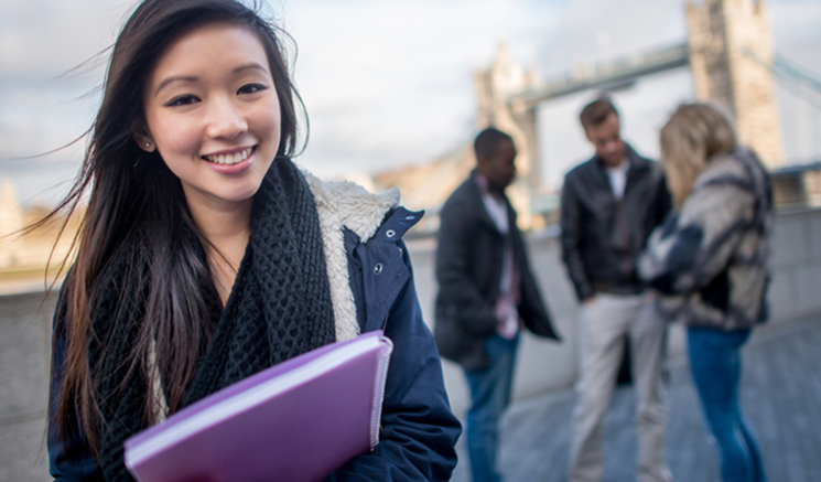 Mujer asiática feliz estudiando inglés en Londres